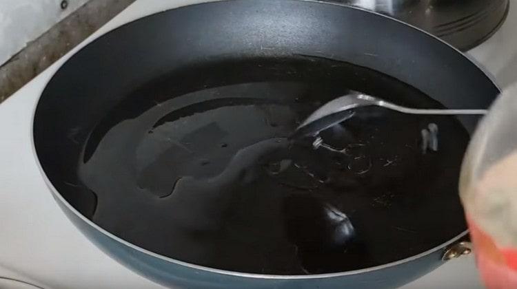 Загрейте тигана с растително масло.
