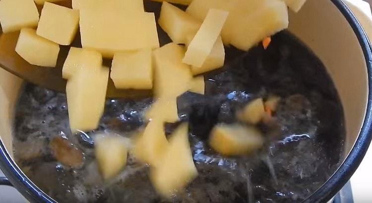 Adăugați cartofii tăiați în ciuperci.