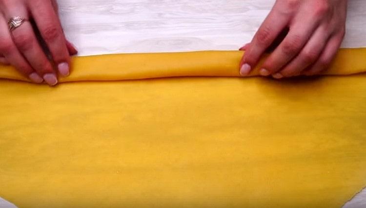 Ensuite, nous tordons la pâte en un rouleau.