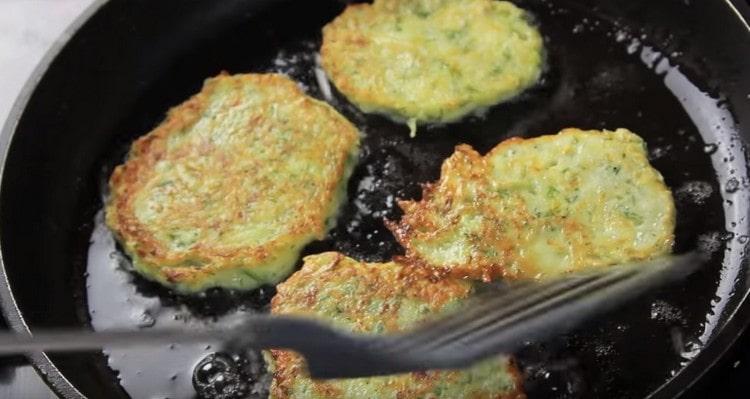 Frire les pancakes de courgettes des deux côtés jusqu'à ce qu'ils soient dorés.