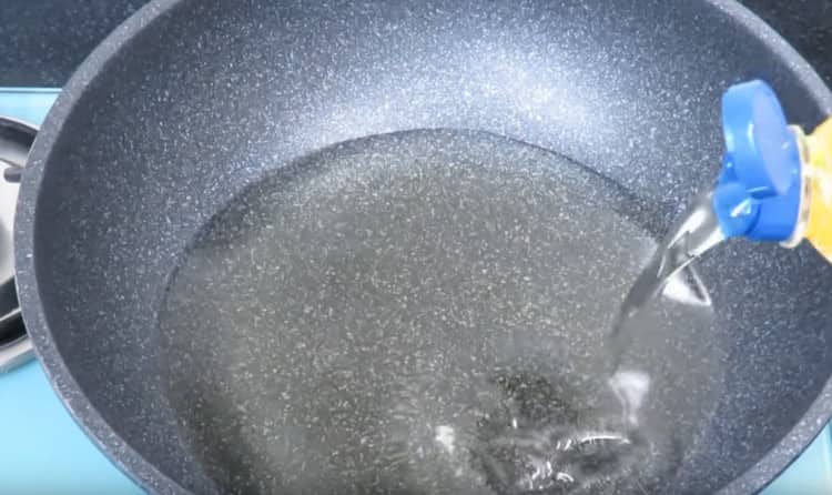 Încălziți uleiul vegetal într-o tigaie wok.