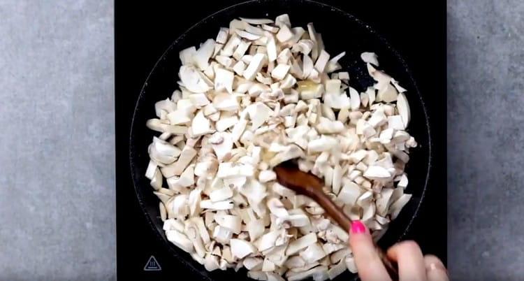 Добавете гъбите към лука.