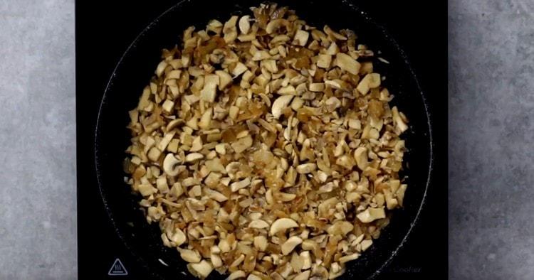 Запържете гъбите с лука, за да се изпари течността.