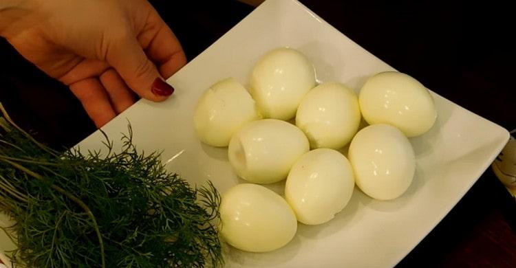 Fierbeți ouăle până la fiert, curățați-le.