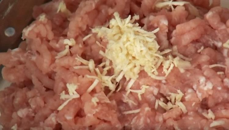 Magdagdag ng tinadtad na sibuyas at bawang sa karne.