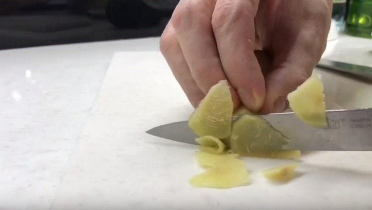 Talleu l’arrel de gingebre a rodanxes fines.