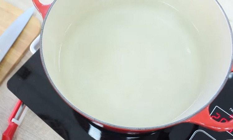 Vi lægger en gryde med vand på ilden.