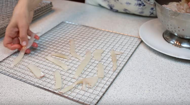 Așezați cu atenție benzile de calamar pe suporturile de uscare.