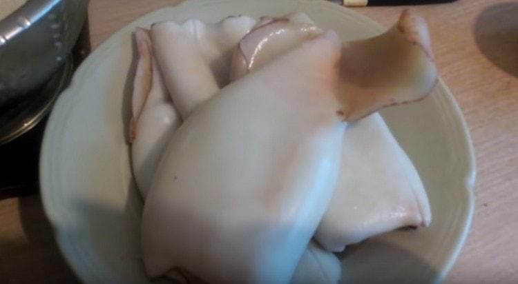 Wir halten den Tintenfisch 2 Minuten lang in kochendem Wasser und säubern ihn dann leicht vom Film.