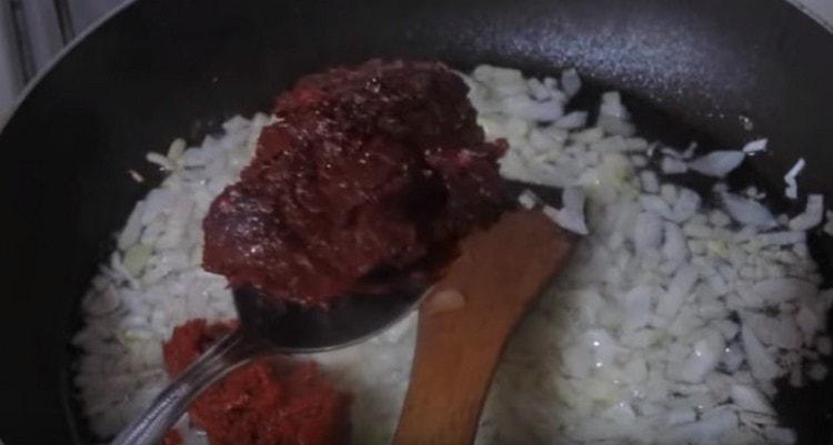 Fügen Sie der Zwiebel Tomatenmark hinzu.