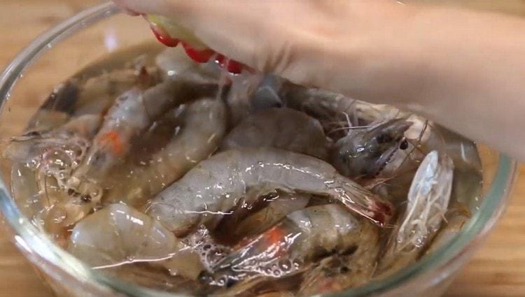 Versez les crevettes lavées avec de l'eau, ajoutez de la vodka soju et le jus d'un demi citron.