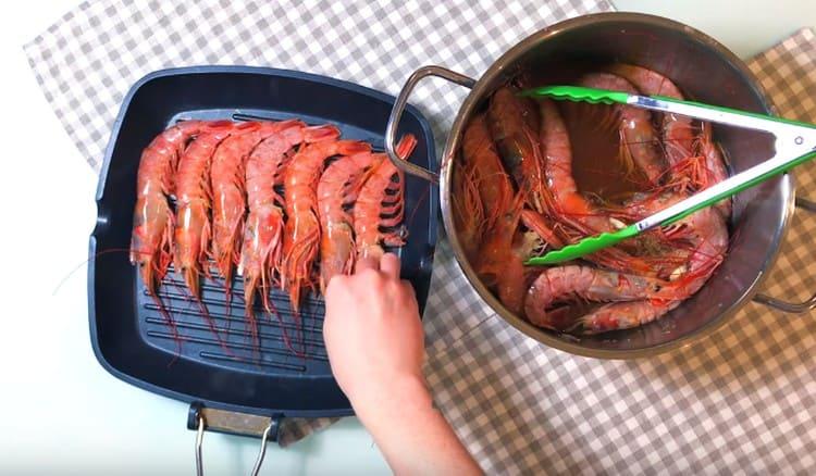 Întindem creveții într-o tigaie încălzită la grătar într-un singur strat.