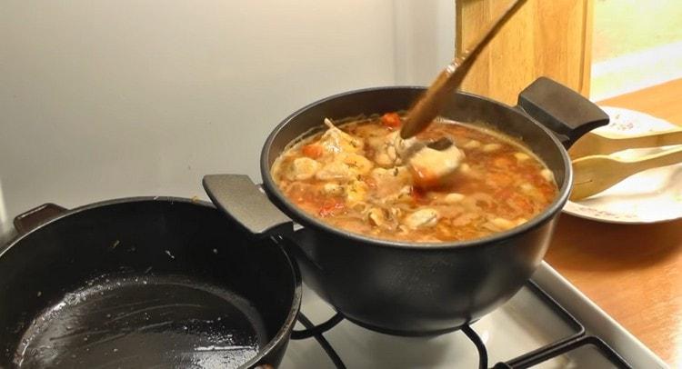 Wir schieben das Huhn zu den Bohnen in der Sauce.