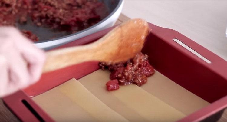 Apoi, întindeți sosul bolognez.