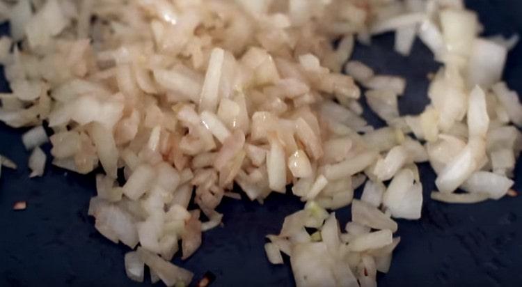 Prăjiți ceapa cu usturoi într-o tigaie până se rumenesc.