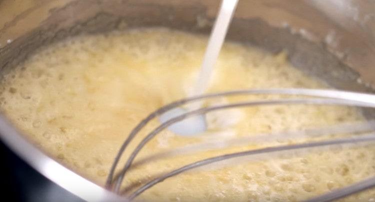 În continuare, introducem laptele și amestecăm masa, spărgând bucățele.