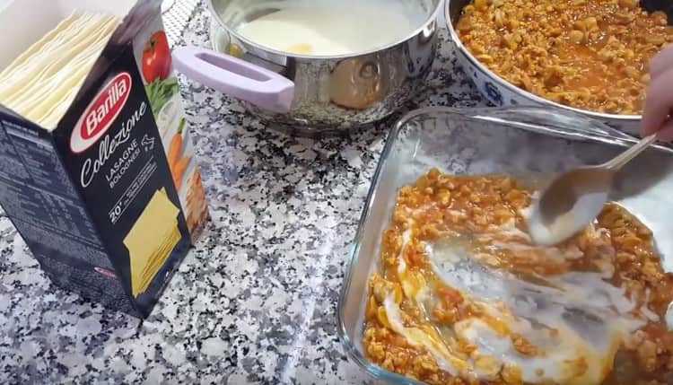 En la parte inferior del formulario, ponga un poco de salsa boloñesa y bechamel, mezcle.