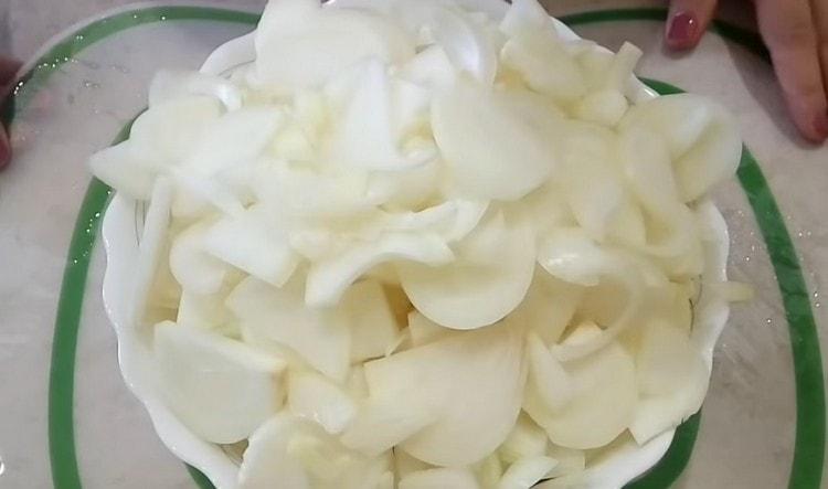 חותכים את הבצל לחצאי טבעות.