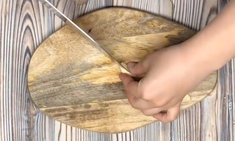 Slib hvidløg med en kniv.