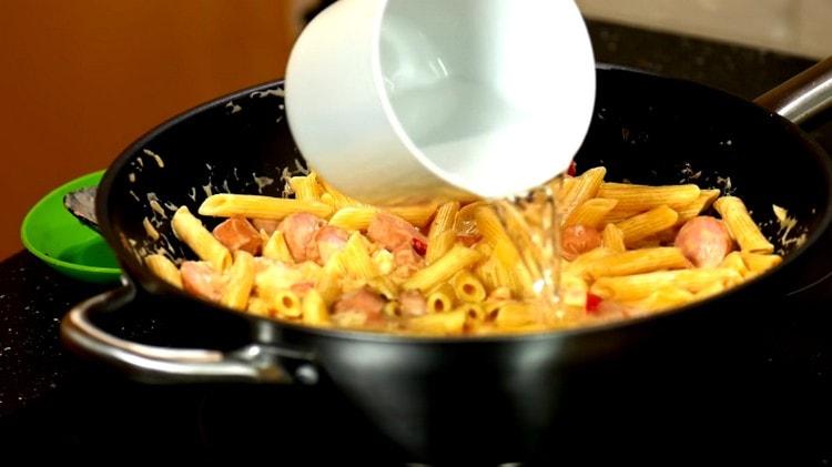 We spread the pasta in the sauce with sausages, add a little water.