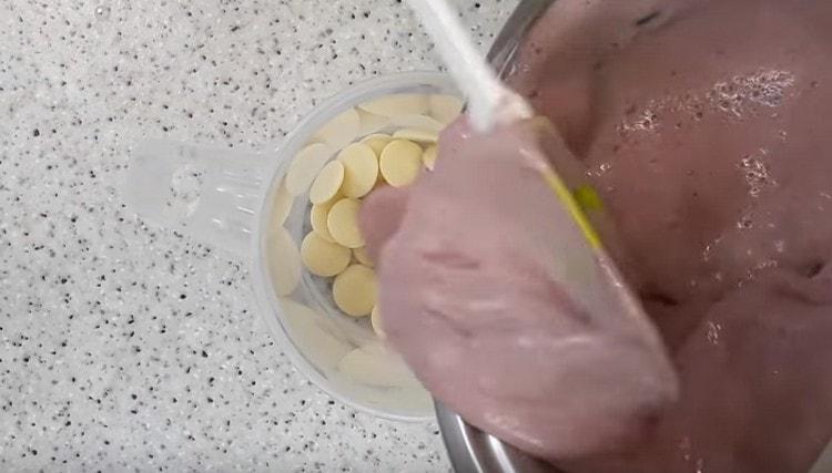 ننشر الكريم الساخن على الشوكولاتة البيضاء.