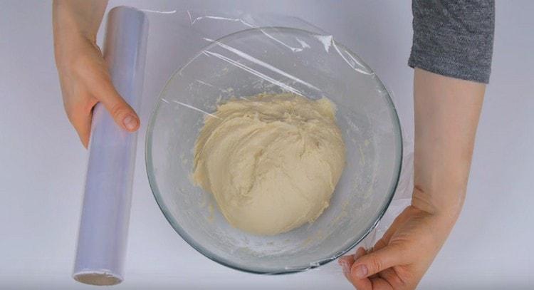 We cover the dough with cling film and let it rise.