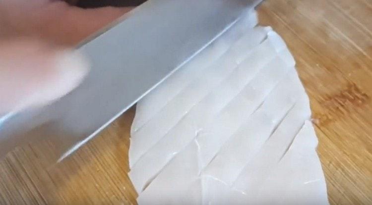 Почистваме калмарите, измиваме ги, нарязваме ги на ивици.