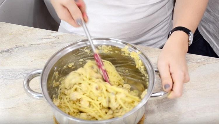 Amestecați spaghetele preparate cu sos de nuci și ciuperci.