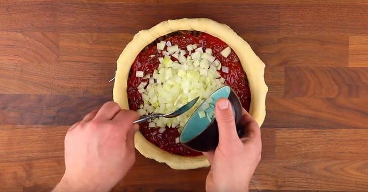 Løg spredt oven på saucen.