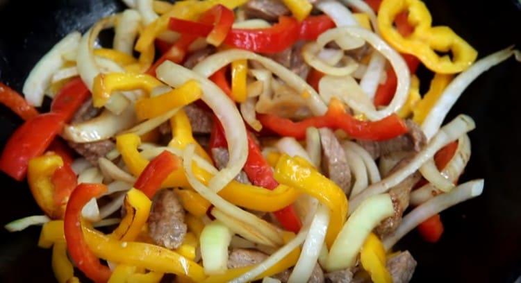 Agregue pimienta y cebolla a la carne, mezcle.