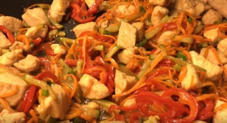 Adăugați toate legumele la pui în tigaie, amestecați.