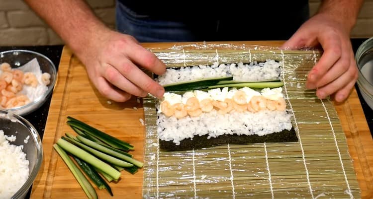 Pe de o parte din brânză întindem creveții, iar pe de altă parte adăugăm castraveții.