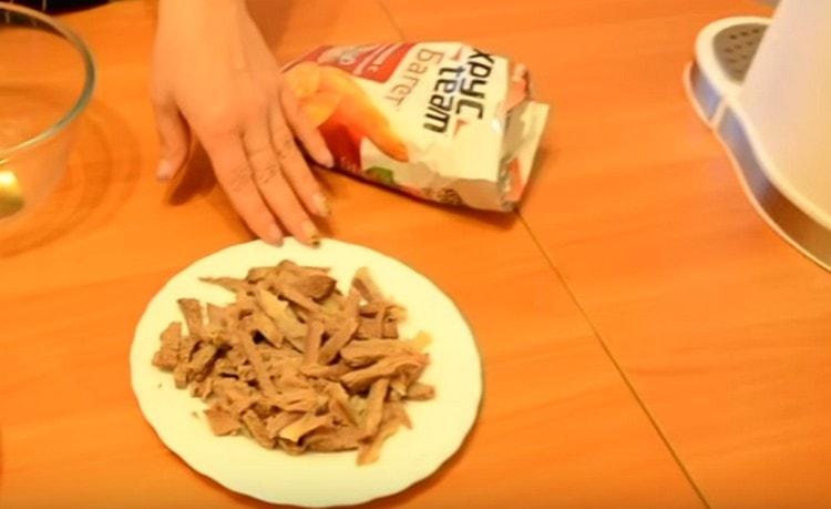 Gekochtes Rindfleisch in Streifen schneiden.