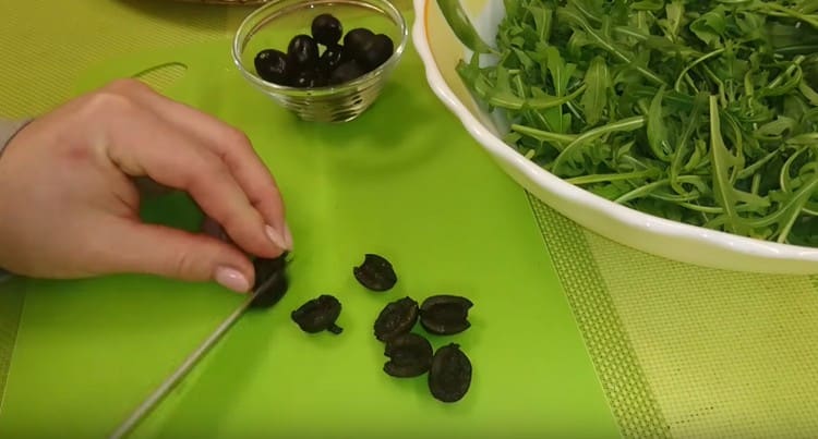 Нарязваме и маслините наполовина.
