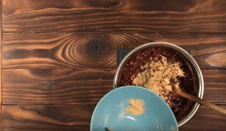 En una masa de chocolate untamos una mezcla de galletas y nueces, mezclamos.