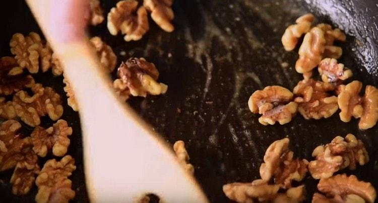 Prăjiți nucile în unt.
