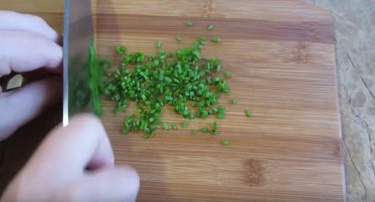 Rozdrťte peří čerstvé zelené cibule.