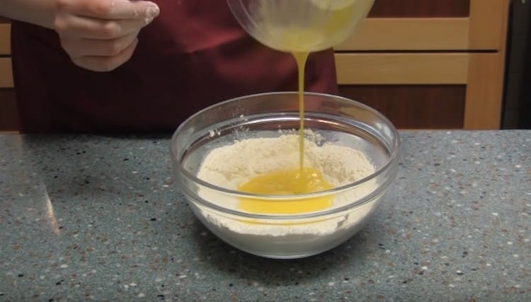 Im Mehl machen wir eine Vertiefung und gießen die Eier hinein.