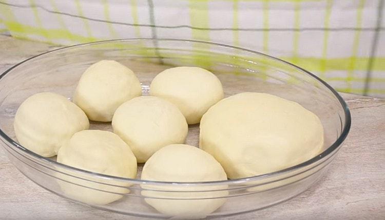 Заготовките за пица се подреждат в предварително намазана с масло форма и се оставят на топло място.