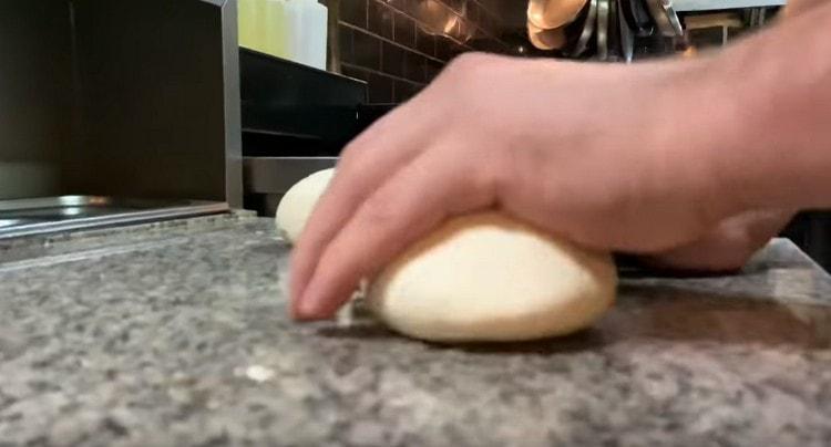 Turnăm bucăți de aluat pe masă.