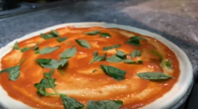 Întindeți frunzele de busuioc deasupra sosului.