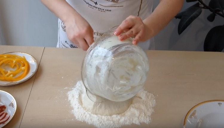 Schimbăm aluatul în făină.