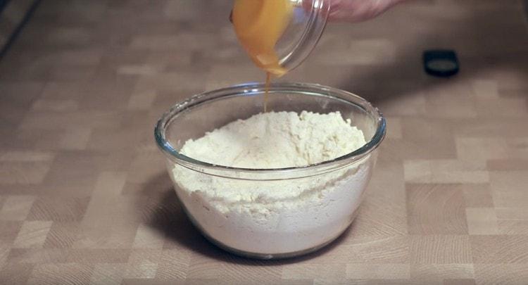 Adăugați oul la masa de făină.