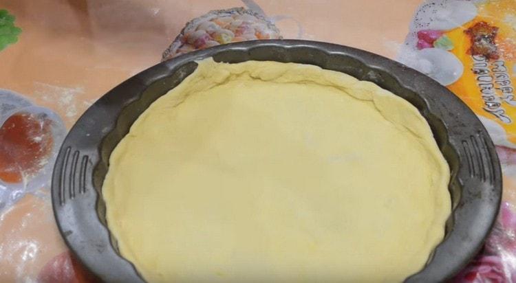 Разпределяме тестото в кръгла форма.