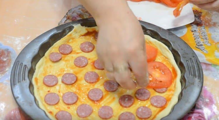 Поставете домати отгоре на колбаса.