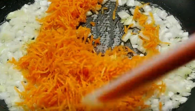 Dalam kuali, goreng bawang cincang dan wortel.