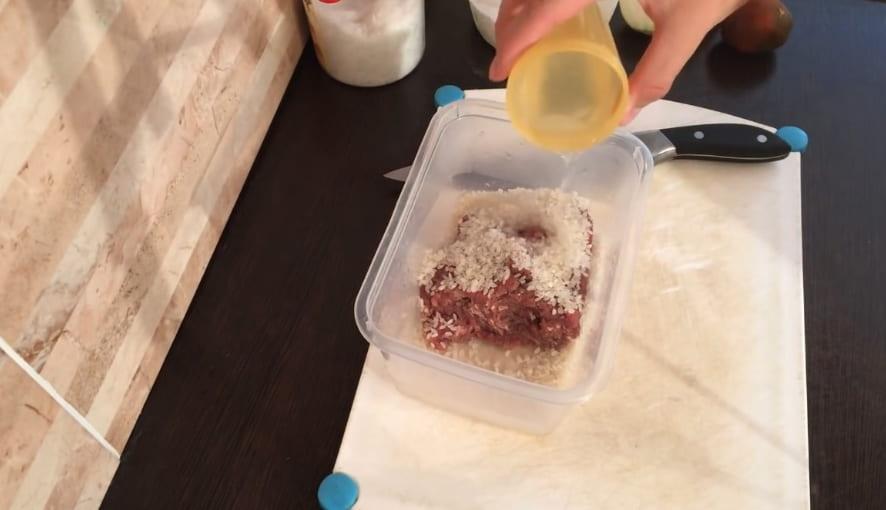 Adăugați orez, sare, apă în carnea tocată.