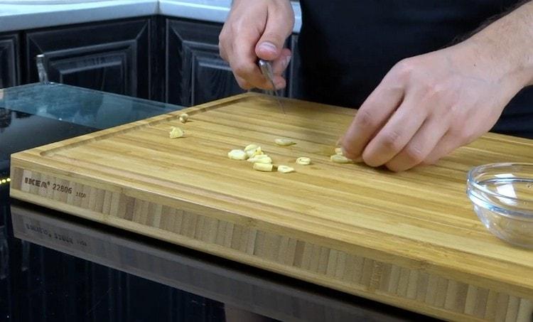 חותכים שום לפרוסות דקות.