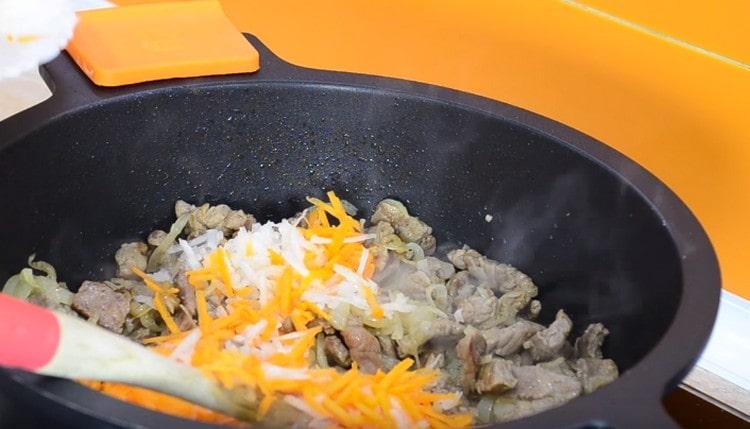 Agregue zanahorias a la carne con cebolla.