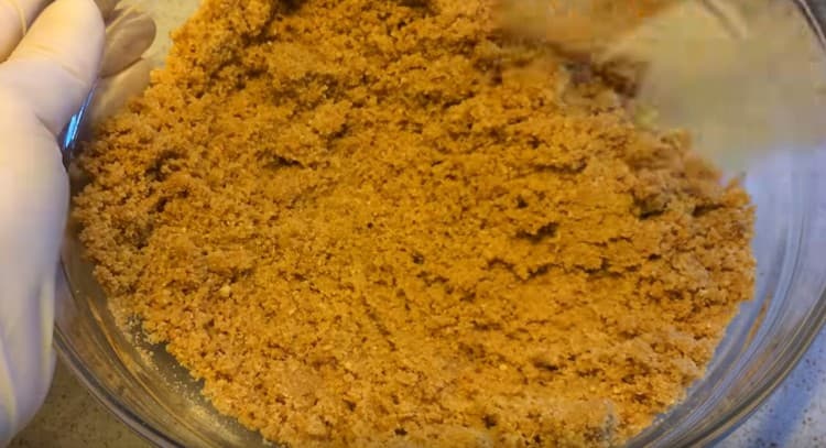 Смесете трохите от бисквитките с маслото.